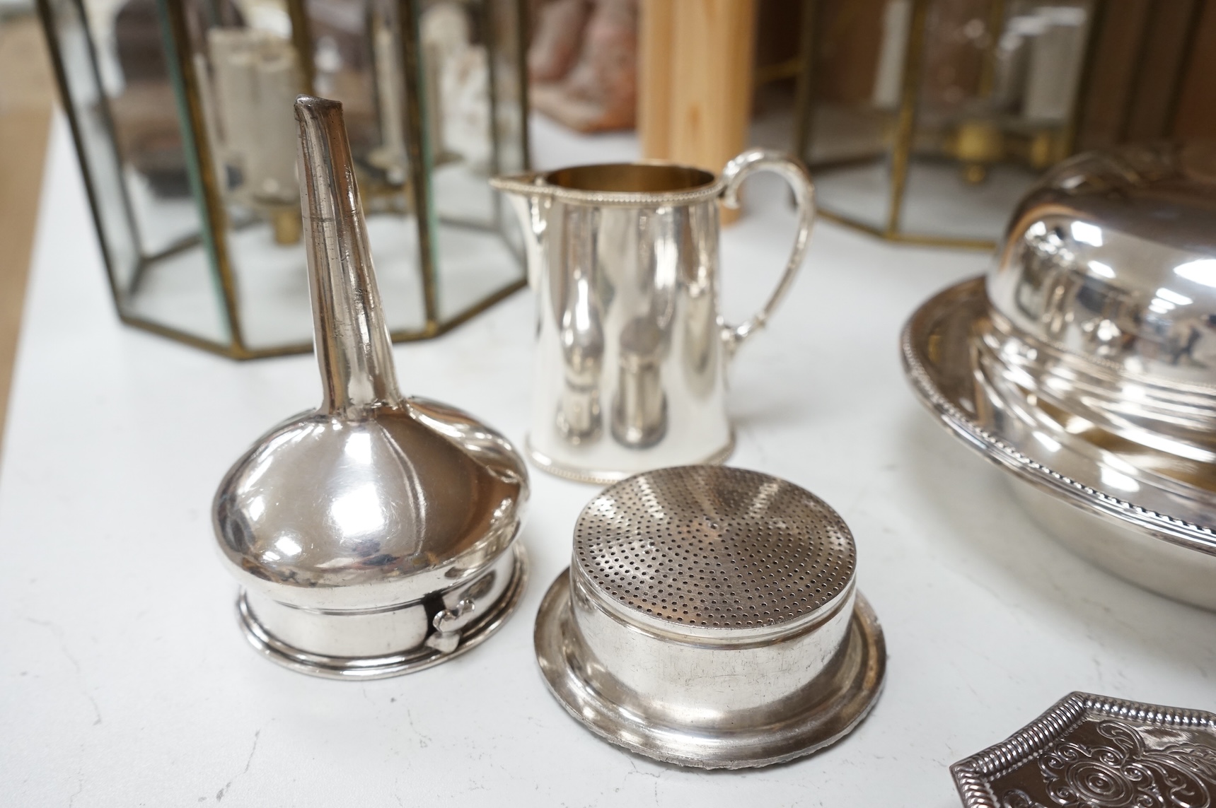 A Mappin plated muffin dish and six other plated items including three Old Sheffield plate butter shells, a wine funnel, Elkington & Co cream jug and cased set of tea knives.
